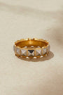 Gold ring with pyramid-shaped stones on a beige background