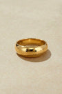 High polished gold ring on a beige background